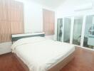 Spacious bedroom with hardwood floors and large bed