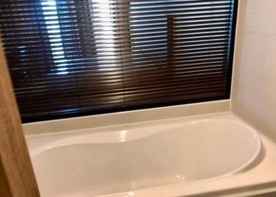 Modern bathroom with bathtub and window blinds