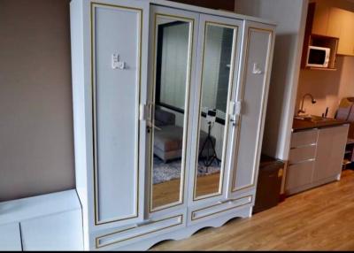 Elegant white wooden wardrobe with mirrored doors in a kitchen interior
