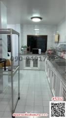 Spacious kitchen with white tiles and modern appliances