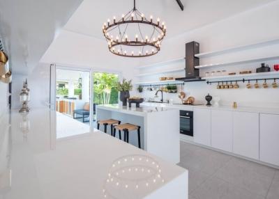 Modern white kitchen with island and chandelier
