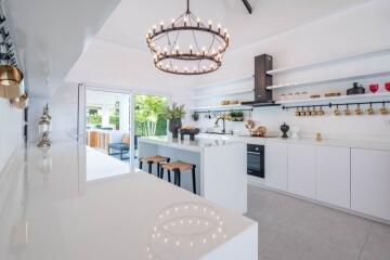 Modern white kitchen with island and chandelier