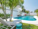 Private swimming pool with sun loungers in a backyard