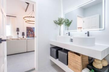 Modern bathroom interior with double sink and view into living room area