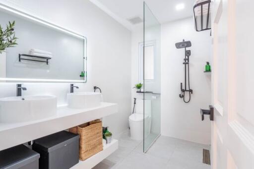 Modern bathroom with double vanity and glass shower enclosure