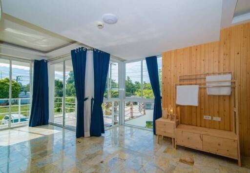 Bright and spacious living room with wooden accents and balcony access