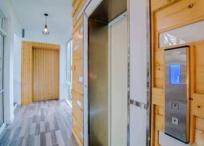 Modern residential hallway with elevator and wooden accents