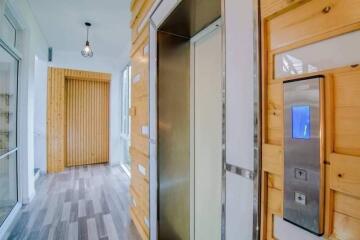 Modern residential hallway with elevator and wooden accents