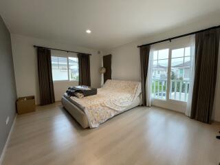 Spacious bedroom with hardwood floors and large windows