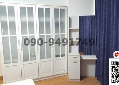 Bright and spacious bedroom with large wardrobe and blue curtains