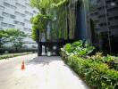 Modern building entrance with lush greenery and glass facade