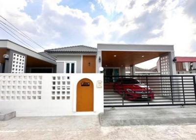 Modern single-story house exterior with carport and gated entrance