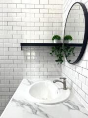 Modern bathroom with white subway tiles and round mirror