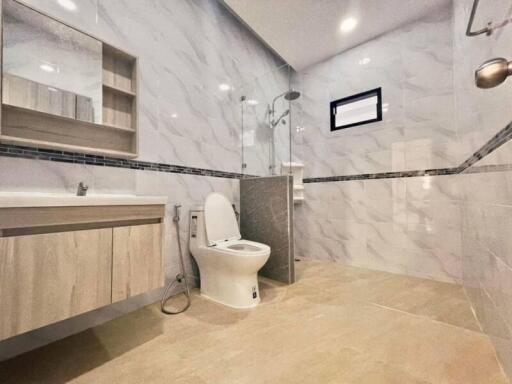 Modern bathroom with marble tiles and wooden vanity