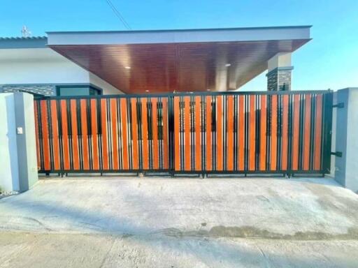 Modern house with orange gate and concrete driveway