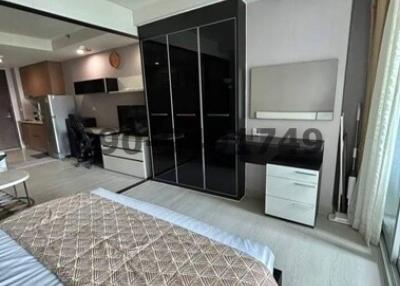 Modern bedroom with large bed, mirrored wardrobe, and attached living area