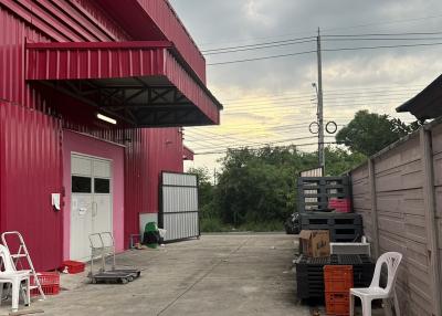 Red industrial building exterior with storage area