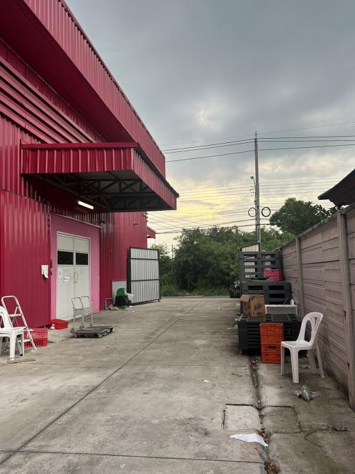 Red industrial building exterior with storage area