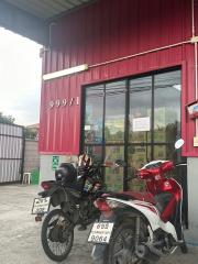 Exterior view of a commercial building with large windows and motorcycles parked in front