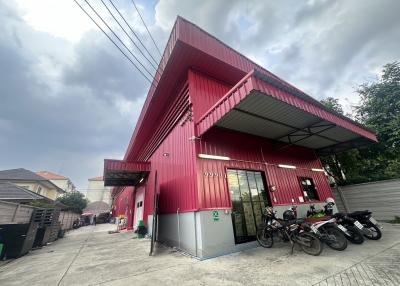 Exterior of a modern red building with motorcycles parked outside