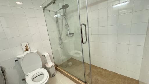 Modern bathroom with glass shower enclosure and white tiling