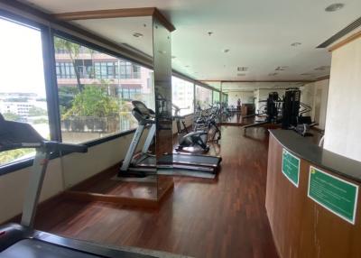 Spacious gym area with modern equipment and large windows