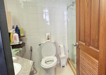 Bright bathroom with white tiles and wooden accents