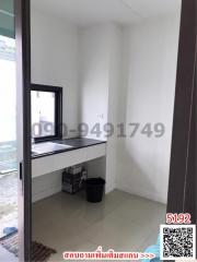 Compact kitchen area with white tiles and a window