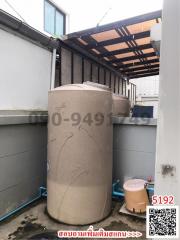 Large water storage tanks in outdoor utility area of property