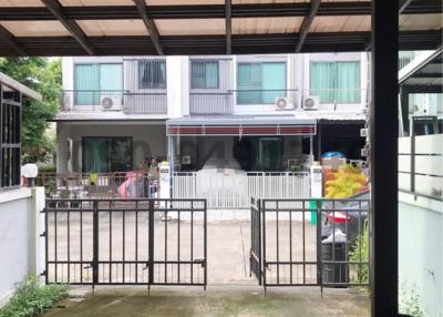 View of a residential building with parking space and balcony from an undercover area