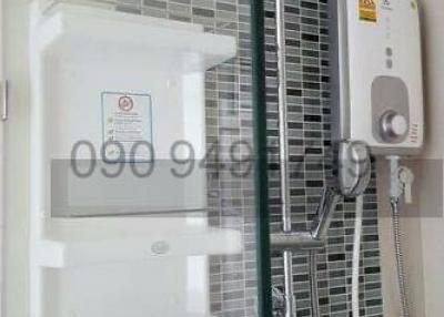 Modern bathroom shower wall with mounted water heater and soap dish