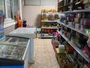 Well-stocked small grocery store interior with various products and freezer