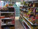 Interior view of a small grocery store with shelves stocked with various products