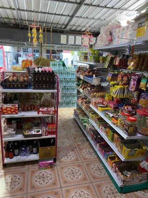 Interior view of a small grocery store with shelves stocked with various products