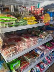 Shelves stocked with various food and household items in a convenience store