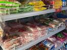 Shelves stocked with various food and household items in a convenience store