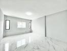 Spacious and bright empty interior space with marble flooring and ample natural light