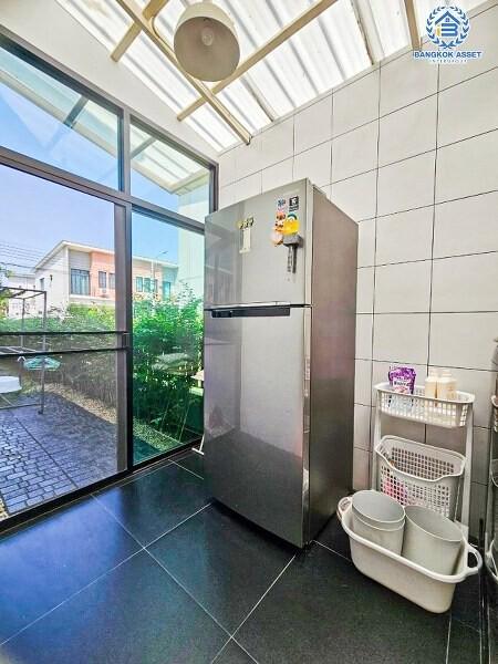 Modern kitchen area with large refrigerator and ample natural light