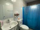 Compact bathroom with white fixtures and blue shower curtain
