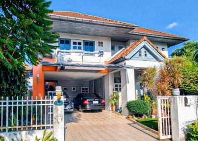 Exterior view of a two-story residential house with a carport and balcony