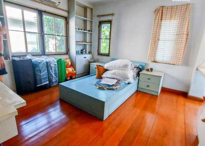 Spacious bedroom with hardwood flooring and ample natural light