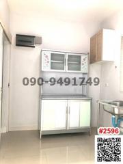 Compact modern kitchen with stainless steel sink and white storage cabinets