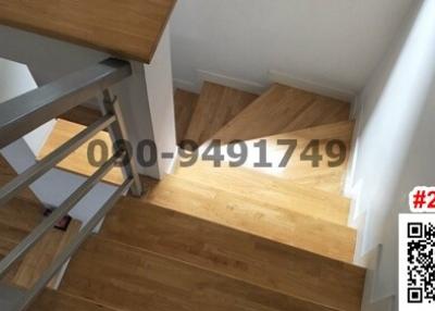 Modern wooden staircase with white balusters and natural light