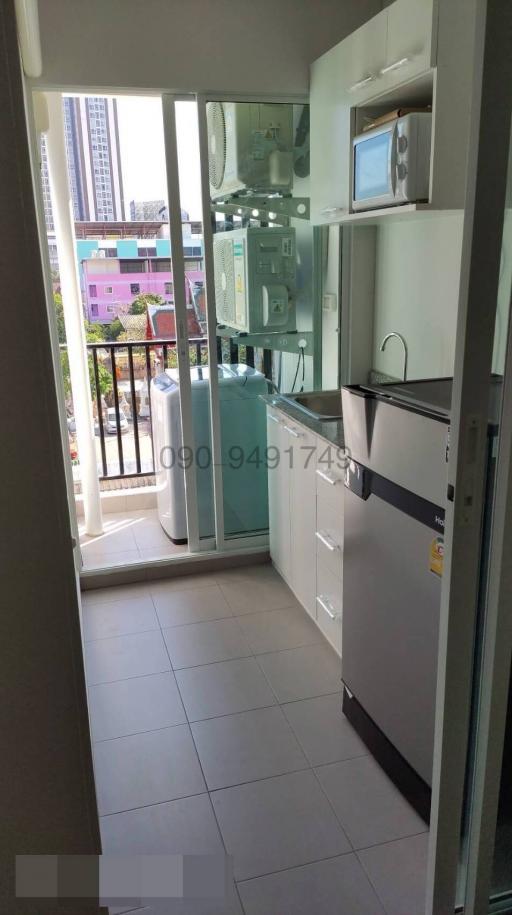 Compact kitchen with modern appliances and balcony access