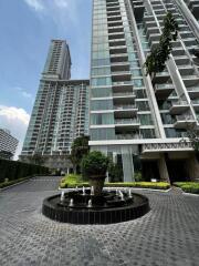 Exterior view of a modern apartment complex with a fountain