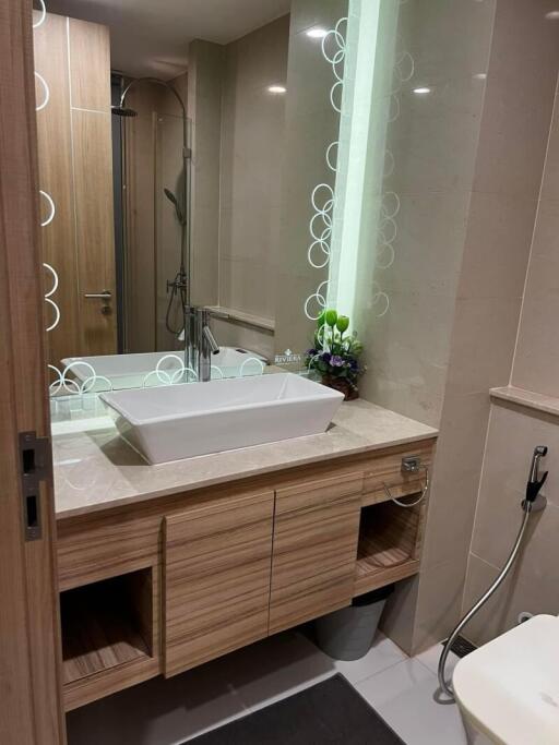 Modern bathroom with spacious vanity, large mirror, and glass shower