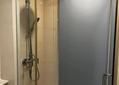 Modern frameless glass shower with stainless steel fixtures in a bathroom