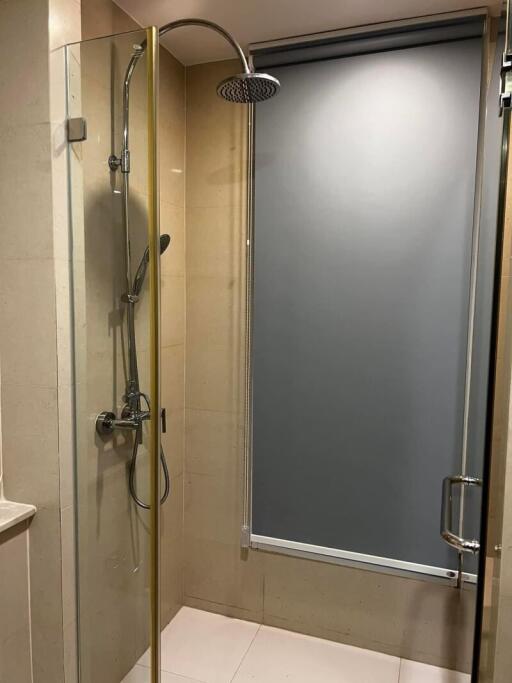 Modern frameless glass shower with stainless steel fixtures in a bathroom