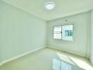 Bright empty bedroom with a large window and glossy tiled floor