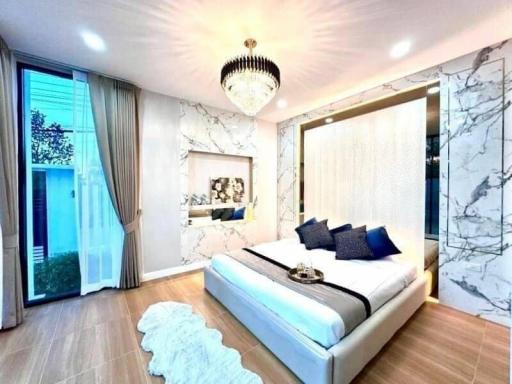 Modern bedroom with elegant decor, marble walls, and ample lighting